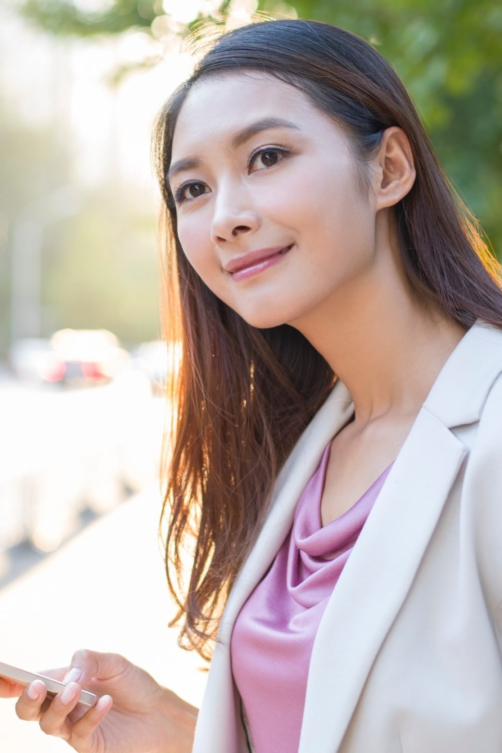 Young woman waiting for taxi with smart phone